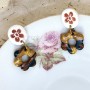 Boucles d’oreilles Bélize avec pampille fleur marbrée doré, vert et citrouille sur ovale blanc estampillé d'une fleur cuivrée