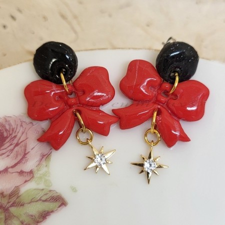Boucles d’oreilles Noélia en pâte polymère rouge et étoile strass, création artisanale De Perles en Bijoux.